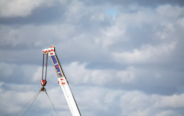 Brazo de la grúa bajo un cielo gris — Foto de Stock