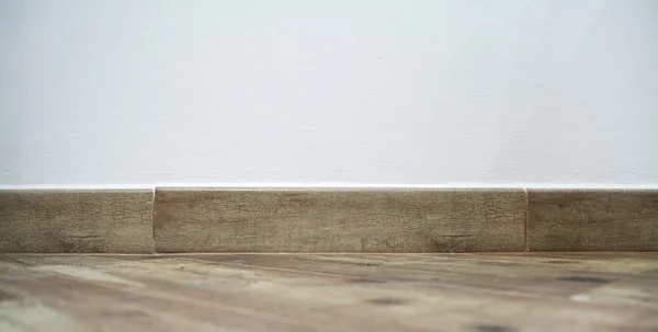 Brun bottenplatta under en vit vägg — Stockfoto