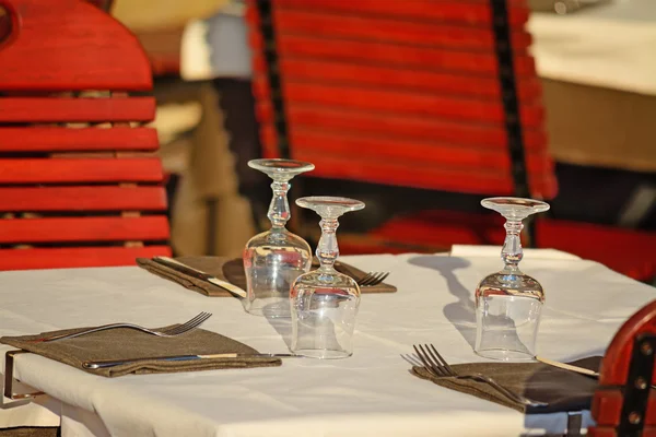 Mesa de restaurante con vasos, tenedores y servilletas Imagen de archivo