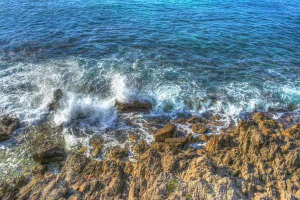 Olas rompiendo sobre rocas marrones —  Fotos de Stock