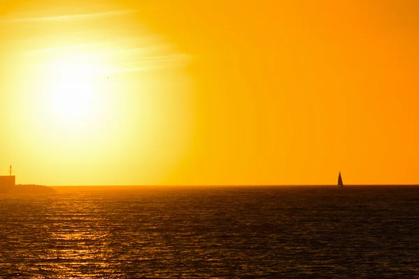 Sam łodzią w morze o zachodzie słońca — Zdjęcie stockowe