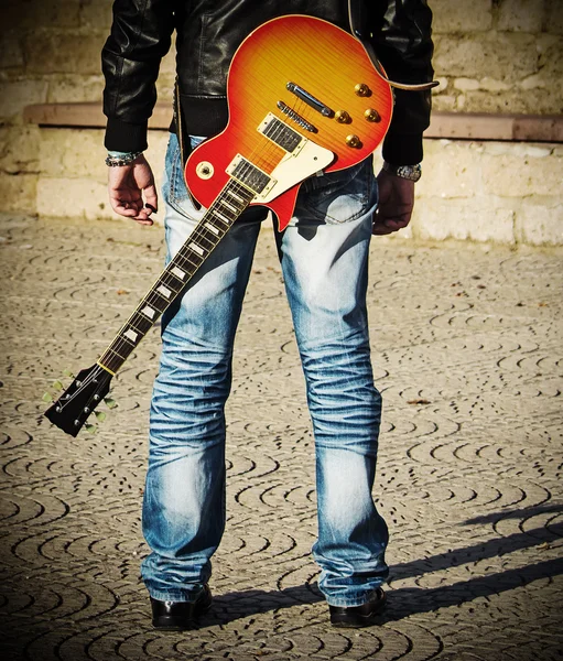 Вид сзади на гитариста, стоящего с гитарой — стоковое фото