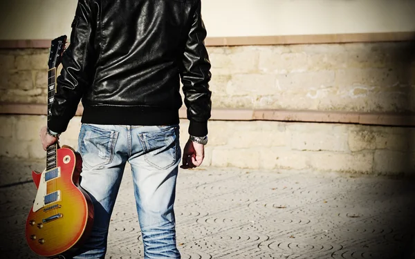 Homem segurando uma guitarra — Fotografia de Stock