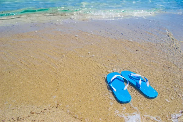 Blauwe sandalen door de kust — Stockfoto