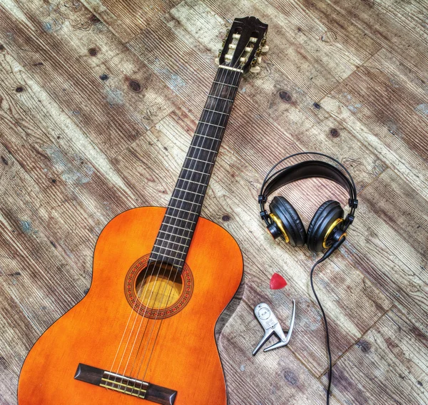 Gitara klasyczna i słuchawki na drewniane deski w hdr — Zdjęcie stockowe