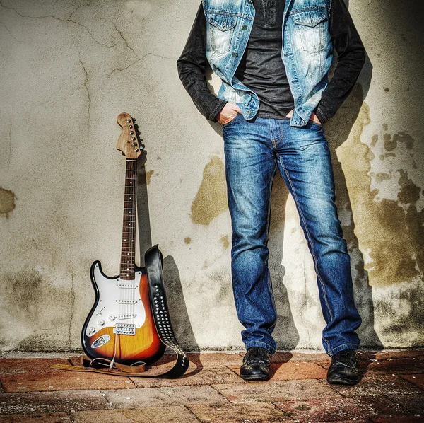 stock image leaning on the wall with an electric guitar