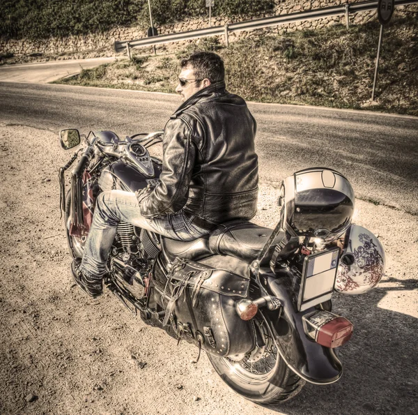 Sidovy av en biker i sepiaton — Stockfoto