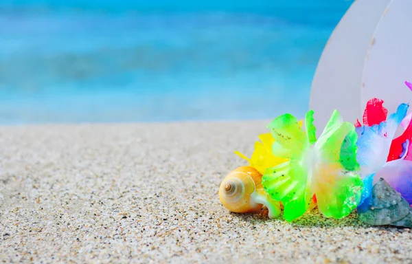 Shell a havajský náhrdelník v písku — Stock fotografie