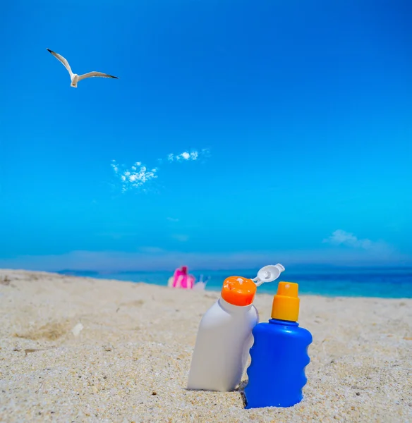 Seagull flying over the suntan lotion bottles — Stock Photo, Image