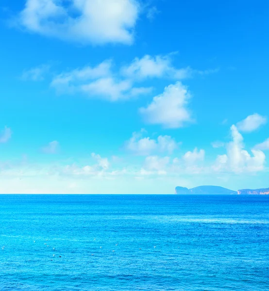 Capo Caccia bajo un cielo azul con nubes —  Fotos de Stock