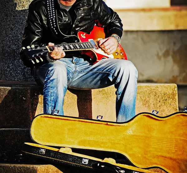 Guitarrista con una caja de guitarra abierta — Foto de Stock