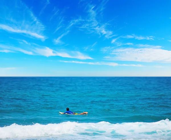 Surfista remando em uma prancha de surf — Fotografia de Stock