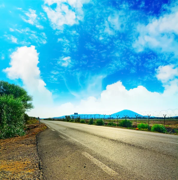 Country road under clouds — Stock Photo, Image