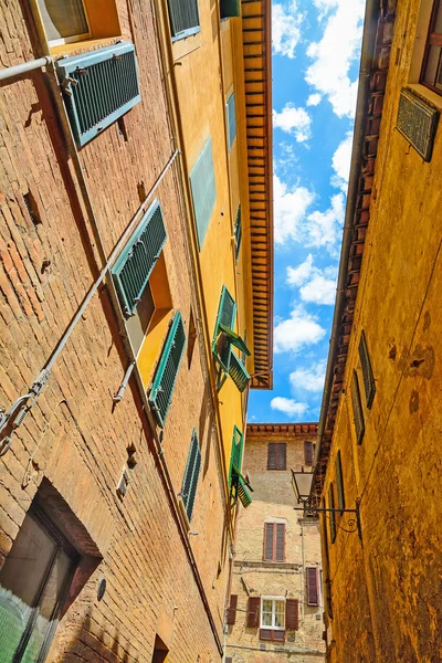 Pequeno backstreet sob um céu azul com nuvens em Siena — Fotografia de Stock