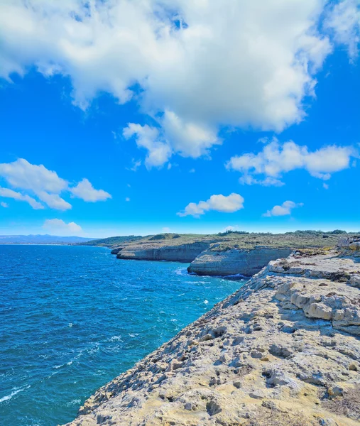 Rocky shore in Porto Torres under huge clouds — Stock Photo, Image