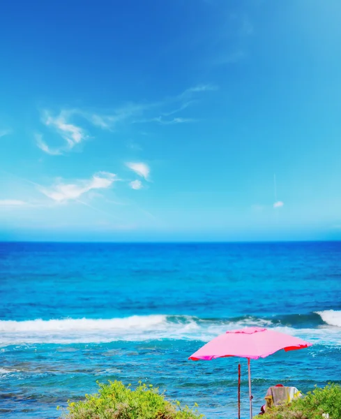 Sombrilla rosa en la playa de Porto Ferro —  Fotos de Stock