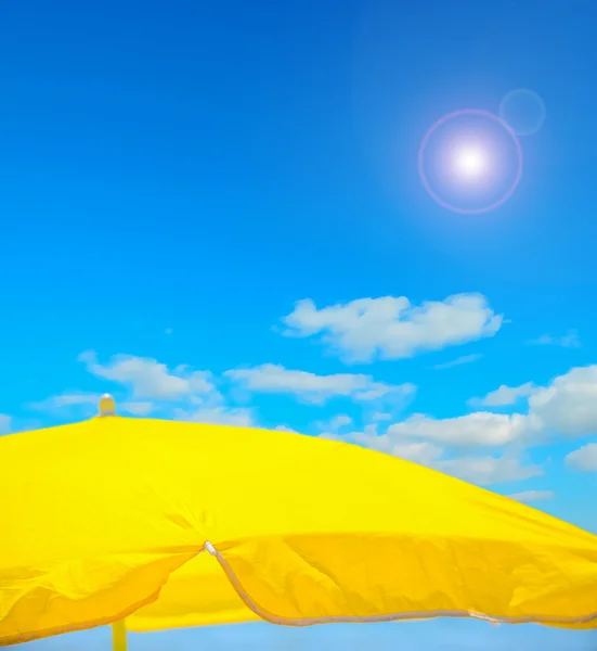 Sombrilla amarilla en la playa bajo un cielo despejado —  Fotos de Stock