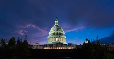 Dünyaca ünlü Birleşik Devletler Kongre Binası gün batımında dramatik bir gökyüzü altında. Washington DC, ABD