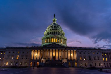 ABD Kongre Binası, National Mall 'da gün batımında dramatik bir gökyüzü altında. Washington DC, ABD