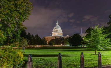 Dünyaca ünlü Birleşik Devletler Kongre Binası geceleri bulutlu bir gökyüzünün altında. Washington DC, ABD
