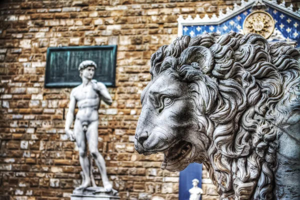 Lion head statue in Lanzi della Loggia with Michelangelo's David — Stock Photo, Image