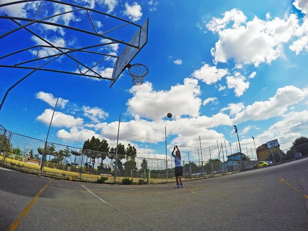 Jugador de baloncesto disparando en un patio de recreo — Foto de Stock