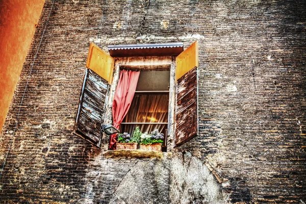 Rustic window in a brick wall in Bologna — Stock Photo, Image