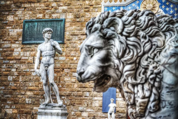 Michelangelo's David with a lion head in the foreground — Stock Photo, Image