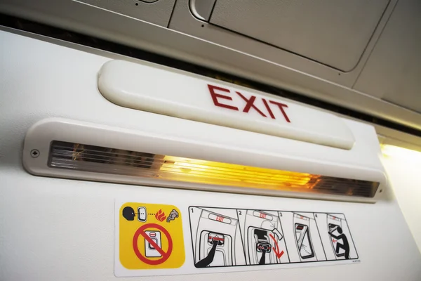 Señal de salida en una cabina de avión commecial —  Fotos de Stock