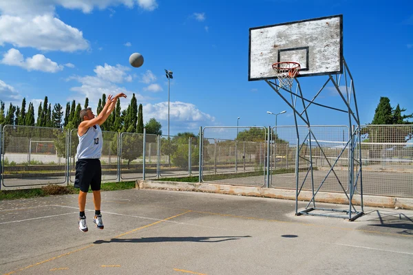 Basketballspieler schießt auf Spielplatz — Stockfoto