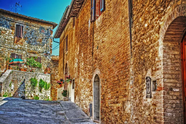 Cihlová zeď a květiny v san gimignano — Stock fotografie