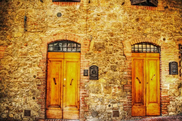 Puertas de madera en una pared de ladrillo en San Gimignano —  Fotos de Stock