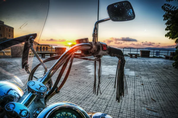 Motocicleta clássica junto ao mar ao pôr do sol — Fotografia de Stock