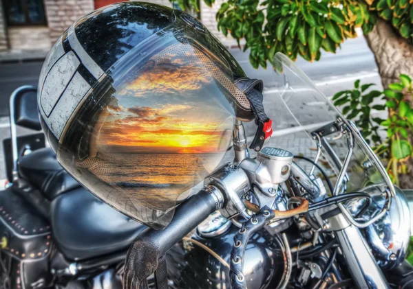 Farbenfroher Sonnenuntergang spiegelt sich auf einem Motorradhelm wider — Stockfoto