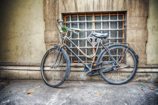 Bicicleta vieja contra una pared rústica en Florencia — Foto de Stock