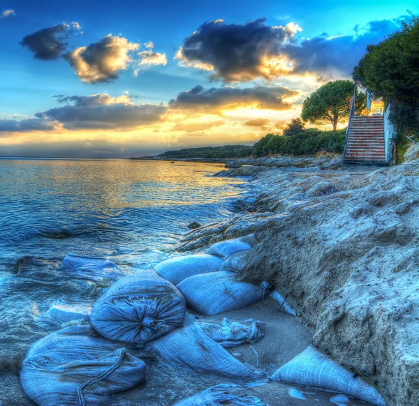 Zand zakken aan de kust bij zonsondergang in Alghero — Stockfoto