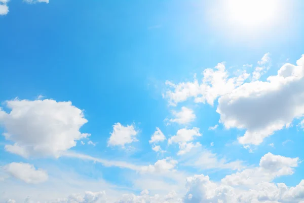 Shining sun in a blue sky with clouds — Stock Photo, Image