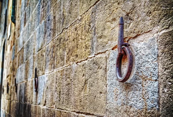 Oude ijzeren hoepel opknoping op stenen muur — Stockfoto