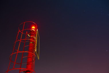 yıldızlı gökyüzü altında küçük kırmızı deniz feneri