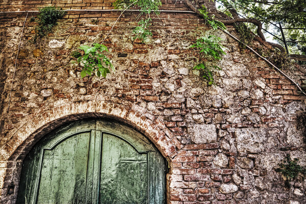 Wooden door in a brick wall in hdr in Siena, Italy