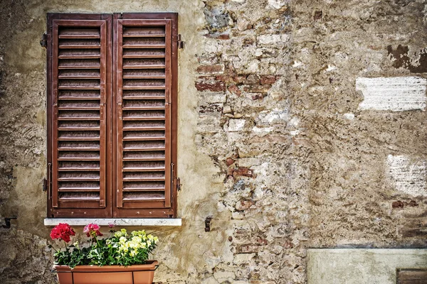 Persianas de ventana marrón en una pared rústica — Foto de Stock