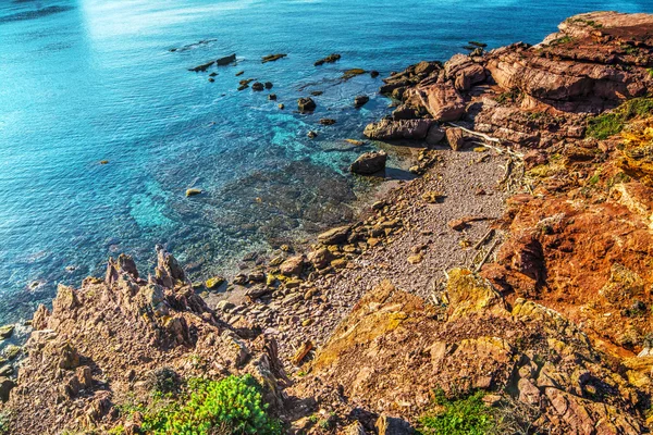 Rode rotsen door de zee — Stockfoto