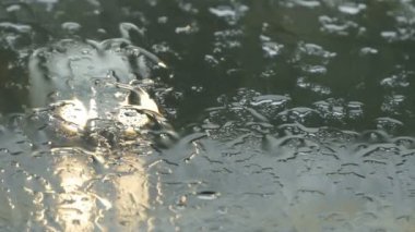 Sonbahar yağmuru damlaları arabanın ön camına düşer.