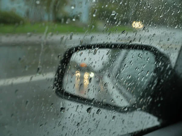 汽车的后视镜车在经过的雨路上 — 图库照片