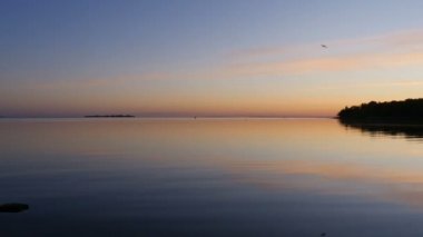 Akşam alacakaranlık manzaralı gün batımı, turuncu gökyüzü göle yansıyor.
