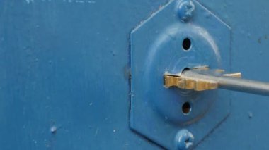 Adam anahtarı anahtar deliğinde çeviriyor, yakın plan, ses ile.