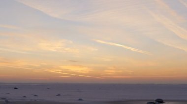 Günbatımı kış güneşi gökyüzünü kırmızı renkli uçak izleriyle boyamış.