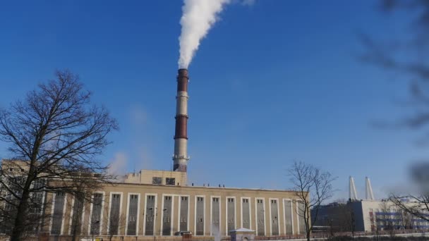火力発電所は煙突を青い空に吸い込み電気と熱を発生させ — ストック動画