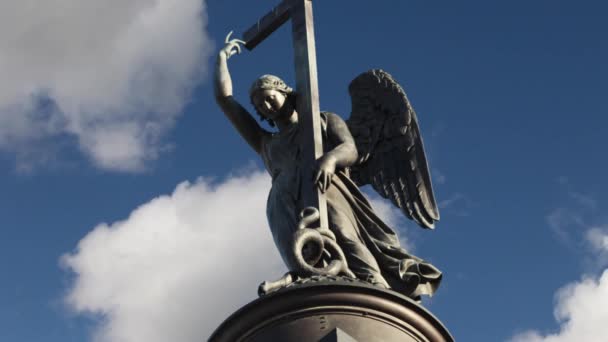 Statue of winged angel with cross in blue sky — Stock Video