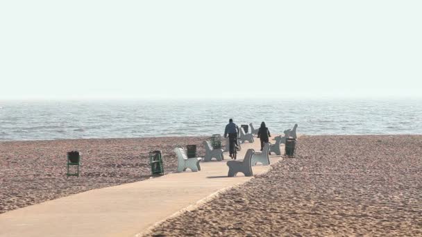 Pareja ciclistas cabalgando en la playa — Vídeos de Stock